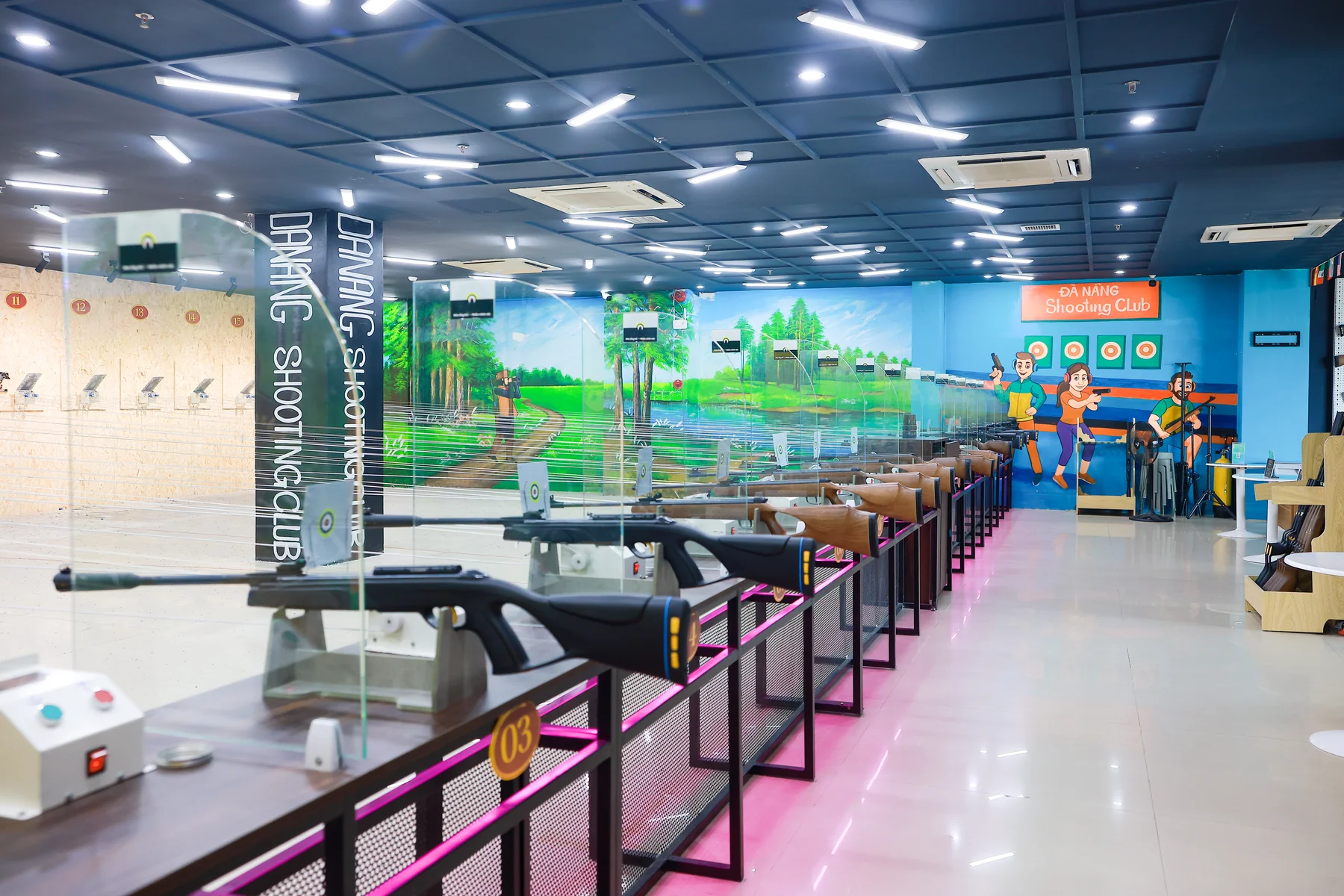 Wide view of the indoor shooting hall with branded banner